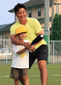 児童にスイングを教える銀次さん